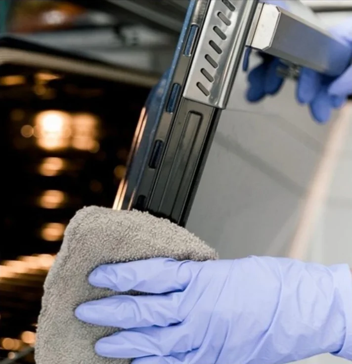 Cleaning an oven door with a cloth