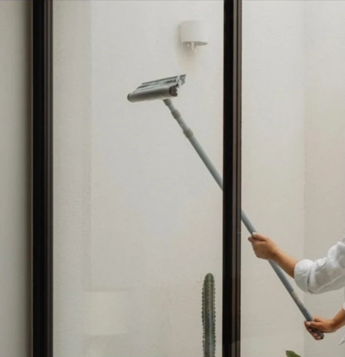 Squeegee cleaning a tall window